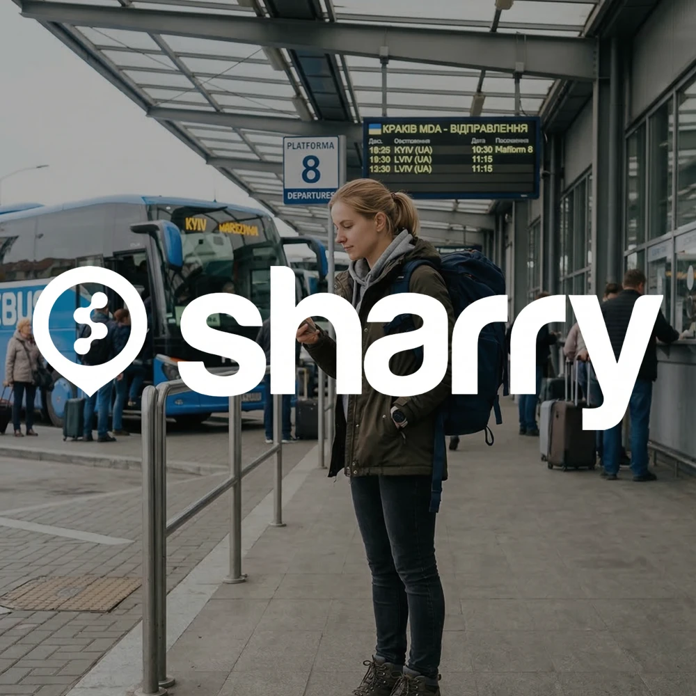 Sharry на фоні жінки, що стоїть з рюкзаком та телефоном на автовокзалі